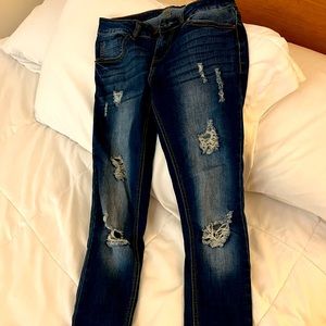 Skinny Blue Age Jeans with multiple holes.